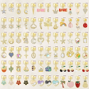 Può includere: Una collezione di ciondoli dorati con vari disegni, tra cui stelle, cuori, fiori e motivi a tema viaggio. Ogni ciondolo è attaccato a una chiusura dorata, adatta per la creazione di gioielli.