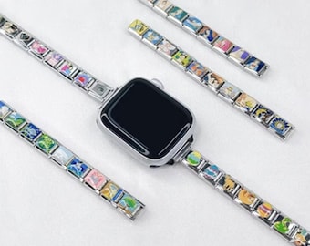 Op de afbeelding: Een zilveren Apple Watch met een zwart scherm, met een bedelarmband. De armband is versierd met kleurrijke, miniatuur illustraties. Extra bedelarmbanden worden in de buurt getoond, met verschillende ontwerpen en kleuren.