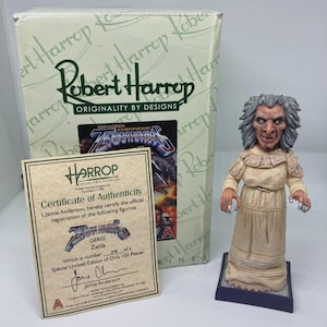 Puede incluir: Figura coleccionable Robert Harrop de Zelda, de la serie Gerry Anderson & Christopher Burrs. Esta figura de edición limitada, número 09 de 150, viene con un certificado de autenticidad. La figura viste un vestido color crema y está sobre una base.