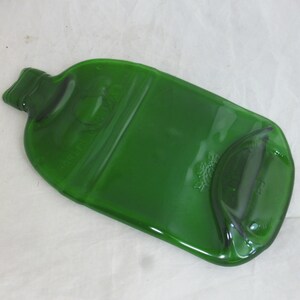 May include: A green glass bottle that has been repurposed into a serving tray. The bottle has been cut and smoothed to create a flat surface.