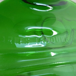 May include: A green glass bottle with the words "JESS LANE" embossed on the bottom.