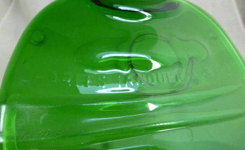 May include: A green glass bottle with the words "JESS LANE" embossed on the bottom.