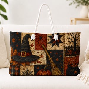 Könnte beinhalten: Eine rechteckige Tragetasche mit weißen Seilgriffen und einem Patchwork-Design mit Halloween-Motiven, darunter ein schwarzer Hexenhut, ein Besen, ein Kürbis, ein Kessel, ein kahler Baum und Sterne in den Farben Schwarz, Orange und Creme.