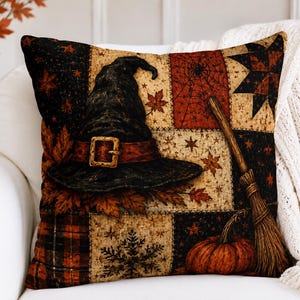 Peut inclure: Un coussin carré avec un motif patchwork aux thèmes automnaux, incluant un chapeau de sorcière noir avec une boucle, un balai, une citrouille, des toiles d'araignée, des étoiles et des feuilles d'érable dans des tons noir, orange, rouge et crème.