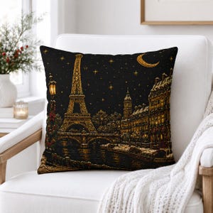 May include: A square throw pillow featuring a nighttime scene of Paris with a golden Eiffel Tower, a crescent moon, and stars against a black background. The design includes a river, a bridge, and illuminated buildings along the bank.
