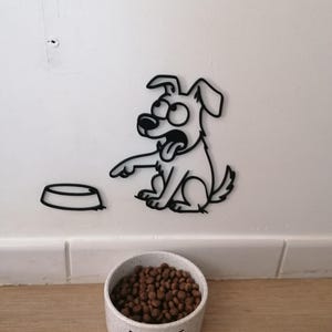 Peut inclure: Un contour noir d'un chien de dessin animé pointant vers un bol vide. Un bol en céramique rempli de nourriture pour chien brune se trouve en dessous du chien. Le mot "EAT" est imprimé sur le bol.