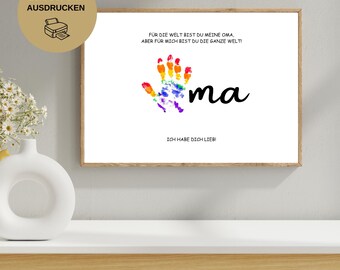 Op de afbeelding: Een ingelijste print met een witte achtergrond toont een kleurrijke handafdruk en het woord "ma" in zwart schrift. De tekst in het Duits luidt "Voor de wereld ben je mijn oma, maar voor mij ben je de hele wereld!" en "Ik hou van je!"