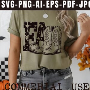 K&ouml;nnte beinhalten: Olivgr&uuml;nes T-Shirt mit schwarzem Grafikdesign. Das Design beinhaltet das Wort "FALL", einen K&uuml;rbis und Cowboy-Stiefel. Das T-Shirt ist im l&auml;ssigen Stil gehalten und eignet sich f&uuml;r den Herbst.