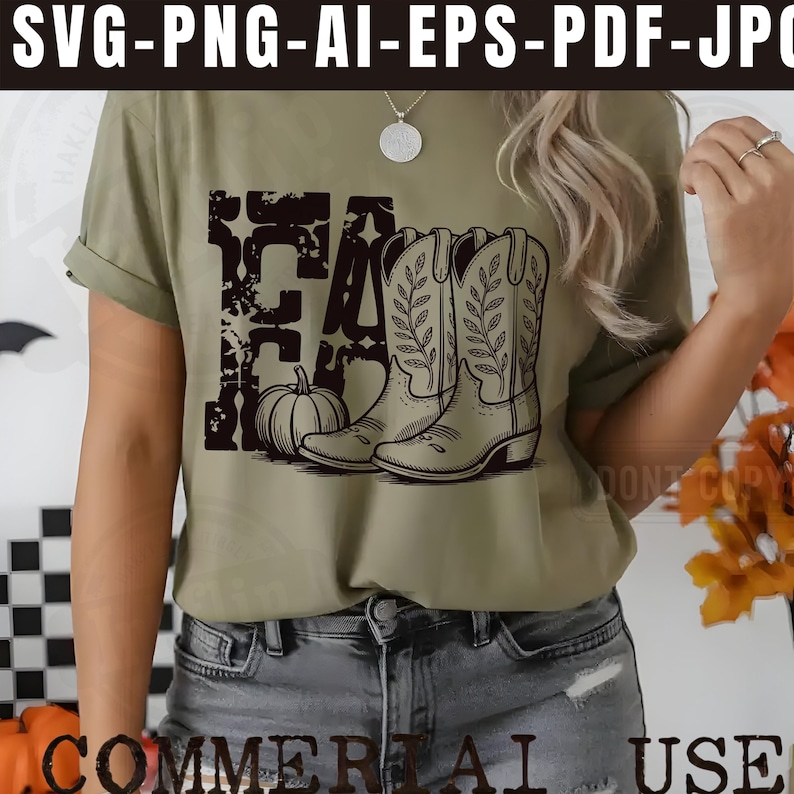 K&ouml;nnte beinhalten: Olivgr&uuml;nes T-Shirt mit schwarzem Grafikdesign. Das Design beinhaltet das Wort "FALL", einen K&uuml;rbis und Cowboy-Stiefel. Das T-Shirt ist im l&auml;ssigen Stil gehalten und eignet sich f&uuml;r den Herbst.