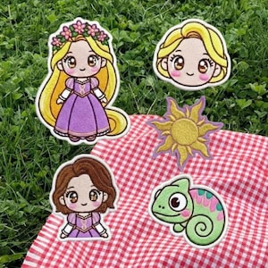 May include: Embroidered patches featuring cartoon characters with large eyes and floral accents. The patches include a princess in a purple dress, a sun, a chameleon, and two other princess faces. The patches are on a red and white checkered cloth.