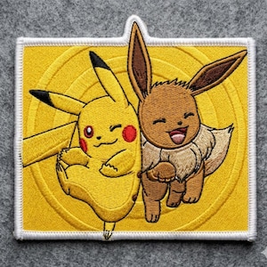 May include: Embroidered patch featuring Pikachu and Eevee from the Pokémon series. Pikachu is yellow with red cheeks, and Eevee is brown with a fluffy neck. The patch has a white border and a yellow background with a circular design.