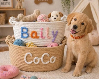 May include: Two woven rope baskets, one white and one tan, are filled with dog toys. The white basket has the name "Baily" in colorful letters. The tan basket has the name "Coco". A golden retriever puppy sits nearby.