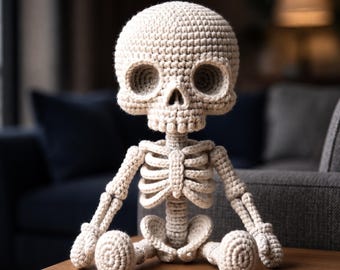 May include: A beige crochet skeleton figure featuring a large rounded skull with deep eye sockets, a central nasal cavity, and a detailed rib cage structure. The figure has articulated limbs and a seated posture, crafted with visible yarn stitches.