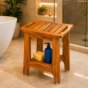 May include: A rectangular wooden shower stool with a slatted top and a lower shelf. The stool features four sturdy legs with silver-toned feet. On the lower shelf sits a blue plastic pump bottle and a rectangular yellow sponge for bathing.
