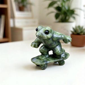 Handskuren serpentinskatergrodastaty, minifigur av grön ädelstensgroda på skateboard, söt skrivbordsdekor, cool present till grodälskare