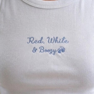 Celebrate in style with our playful Embroidered Red, White & Boozy Croptop. Featuring a charming cursive embroidery and cute clinking beer mug icons, this top is designed for those who love to celebrate American pride with a side of fun!