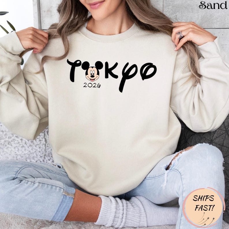 May include: A white ceramic mug with a black handle and the text "But First, Coffee" in a bold, black font. The mug is set against a blurred background, suggesting a cozy setting. The mug appears to be approximately 4 inches tall.