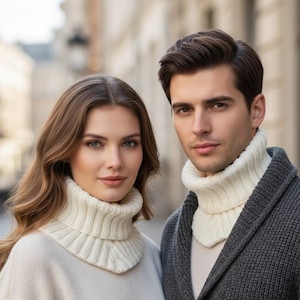 Può includere: Un uomo e una donna indossano scaldacollo a coste color crema. La donna indossa un maglione color crema e l'uomo un cardigan grigio. Il testo "PDF KNITTING PATTERN" è in basso nell'immagine.