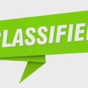 Puede incluir: Una pancarta verde con la palabra "CLASSIFIED" en letras blancas en negrita. La pancarta tiene un diseño plegado, tipo origami, con un extremo puntiagudo. El fondo es gris claro liso.