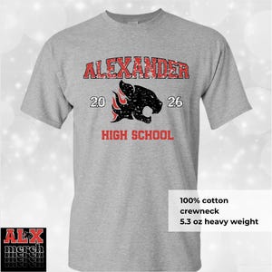 May include: A gray crewneck t-shirt with the text "ALEXANDER HIGH SCHOOL" in red, along with a black panther graphic. The shirt is made of 100% cotton and is 5.3 oz heavy weight.