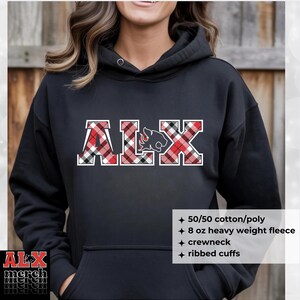 May include: Black hooded sweatshirt with the letters "ALX" in a red, black, and white plaid pattern. The letter "L" features a cougar graphic. The sweatshirt has a crewneck and ribbed cuffs.