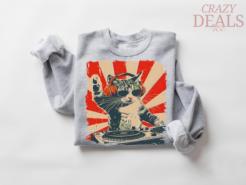 May include: A grey sweatshirt with a graphic of a cat wearing sunglasses and headphones, operating a DJ turntable. The design has a retro style with red and beige accents. The text "CRAZY DEALS" is in the upper right corner.