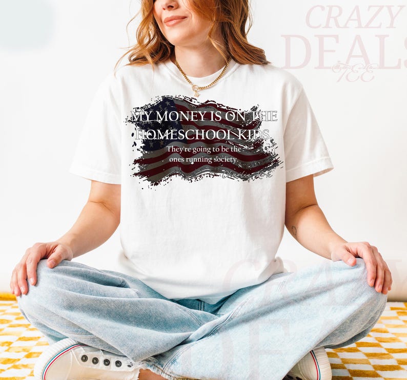 Pu&ograve; includere: T-shirt bianco con la scritta "MY MONEY IS ON THE HOMESCHOOL KIDS" e "They're going to be the ones running society" in nero. Il design include una bandiera americana invecchiata.