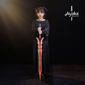 May include: A long, ornate sword with a red and gold blade is held by a person wearing a black dress. The sword has a detailed design and a silver handle. The image includes the text "Ayaka BladeStudio".