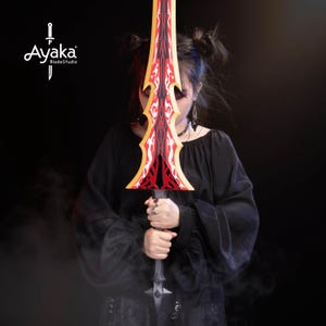 May include: A decorative sword with a red and yellow blade, featuring a detailed design. The sword is held in front of a person wearing a black top. The logo "Ayaka BladeStudio" is visible in the upper left corner.