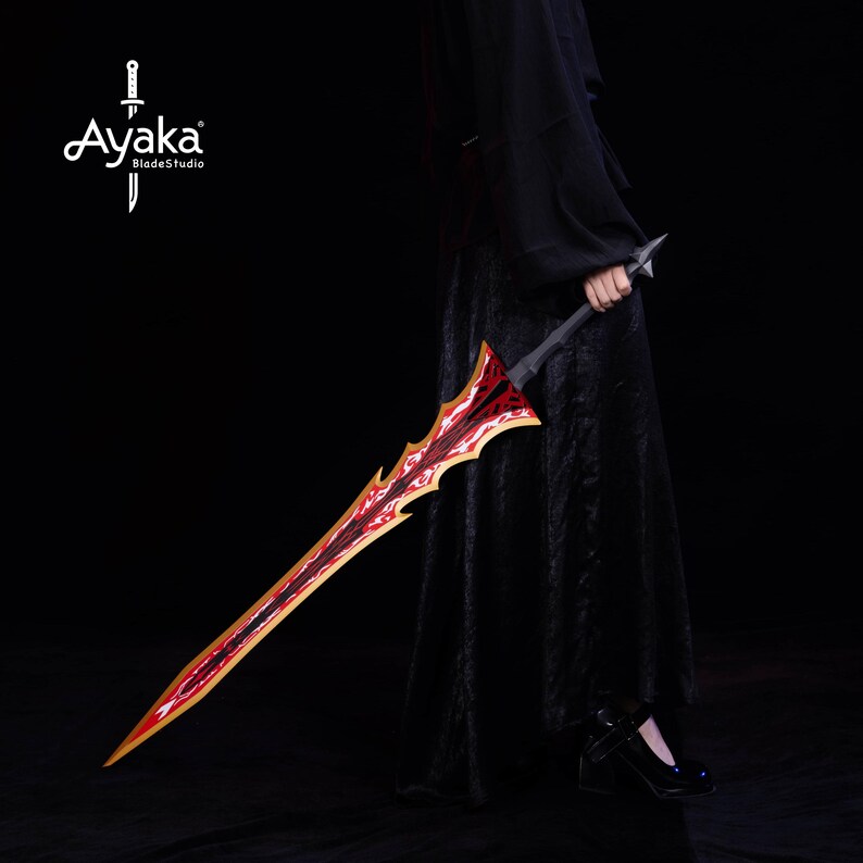 May include: A decorative sword with a red and gold blade and a black handle. The blade has a unique, jagged design. The sword is held by a person wearing a black outfit. The Ayaka BladeStudio logo is in the upper left corner.