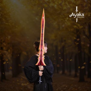 May include: A long, ornate sword with a red and gold blade and handle. The sword has a decorative design along the blade's edge. The sword is held in front of a blurred background of trees and foliage. The logo "Ayaka BladeStudio" is in the upper right corner.