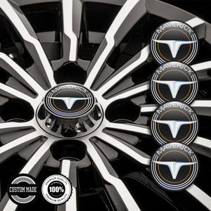 May include: Close-up of a car wheel with a black and white spoke design. The center cap features the word "MAVERICK" and a stylized emblem. Additional caps are visible. Two circular stickers read "CUSTOM MADE" and "PREMIUM QUALITY 100% GUARANTEED".