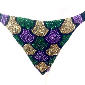 May include: A white ceramic mug with a black handle and the text "But First, Coffee" in a bold, black font. The mug is set against a blurred background, suggesting a cozy setting.