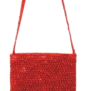 May include: A rectangular red sequin handbag with a matching strap. The bag is covered in small, shiny sequins, giving it a textured appearance. The strap is thin and appears to be made of the same material as the bag.