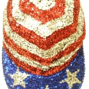 May include: A baseball cap completely covered in shimmering sequins. The crown features alternating horizontal stripes of red and silver sequins. The brim is deep blue with silver sequined stars scattered across the surface in a pattern.
