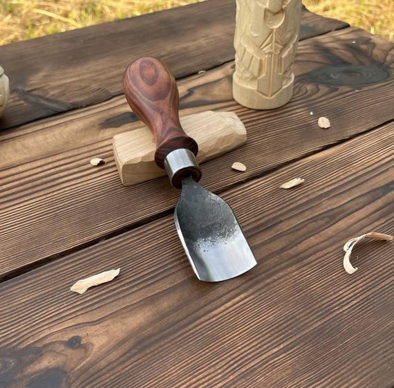 A real blacksmith hand-forged this bent gouge from 52100 high-carbon steel — the kind of tool a serious woodcarver would frame on the wall before ever using it.