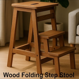 Könnte beinhalten: Ein klappbarer Holz-Trittschemel in hellem Braun. Er hat eine quadratische Oberseite und zwei Stufen mit einem einfachen, funktionalen Design. Der Text "Wood Folding Step Stool" befindet sich am unteren Rand des Bildes.