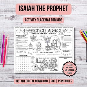 May include: A black and white activity placemat for children featuring the text "Isaiah the Prophet" and various activities. The placemat includes a word hunt, maze, and fill-in-the-blanks. Colour pencils are arranged on the left and right sides of the placemat.