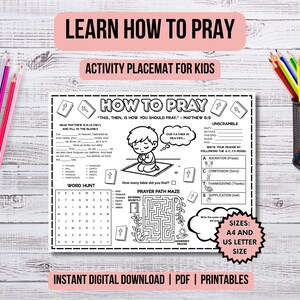 Op de afbeelding: Een zwart-wit activiteit placemat voor kinderen met de tekst "Learn How to Pray". De placemat bevat een woordzoeker, een gebedspad-doolhof en invulsecties. Kleurpotloden en een potloodhouder zijn zichtbaar.