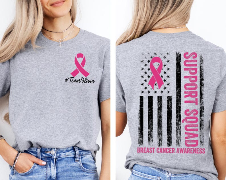 May include: A heather gray t-shirt with a pink ribbon graphic, the text "#TeamOlivia" on the front, and a distressed American flag design with a pink ribbon and the words "Support Squad" and "Breast Cancer Awareness" on the back.