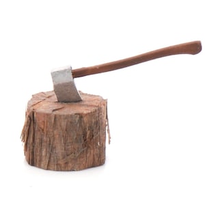 May include: A small axe with a silver head and a brown wooden handle is embedded in a small, textured, brown wooden log. The axe is positioned at an angle, suggesting it has been used for chopping.
