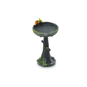 Può includere: Una mangiatoia per uccelli in miniatura con un bacino grigio scuro e una base a forma di tronco d'albero. Il bacino ha una superficie strutturata ed è decorato con muschio verde. Due piccoli uccelli colorati si posano sul bordo.