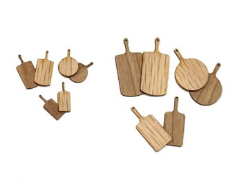 Puede incluir: Un conjunto de 10 tablas de cortar de madera en varias formas y tamaños. Las tablas están hechas de madera natural y tienen un aspecto rústico.