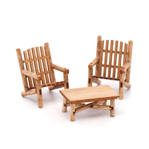 Peut inclure: Ensemble miniature de meubles de patio en bois, comprenant deux fauteuils et une petite table. Les chaises ont un dossier à lattes et des accoudoirs. La table a un plateau rectangulaire et des pieds en croisillon. L'ensemble est en bois brun clair.