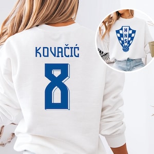 A white sweatshirt with a blue logo and the number 8 printed on the back.