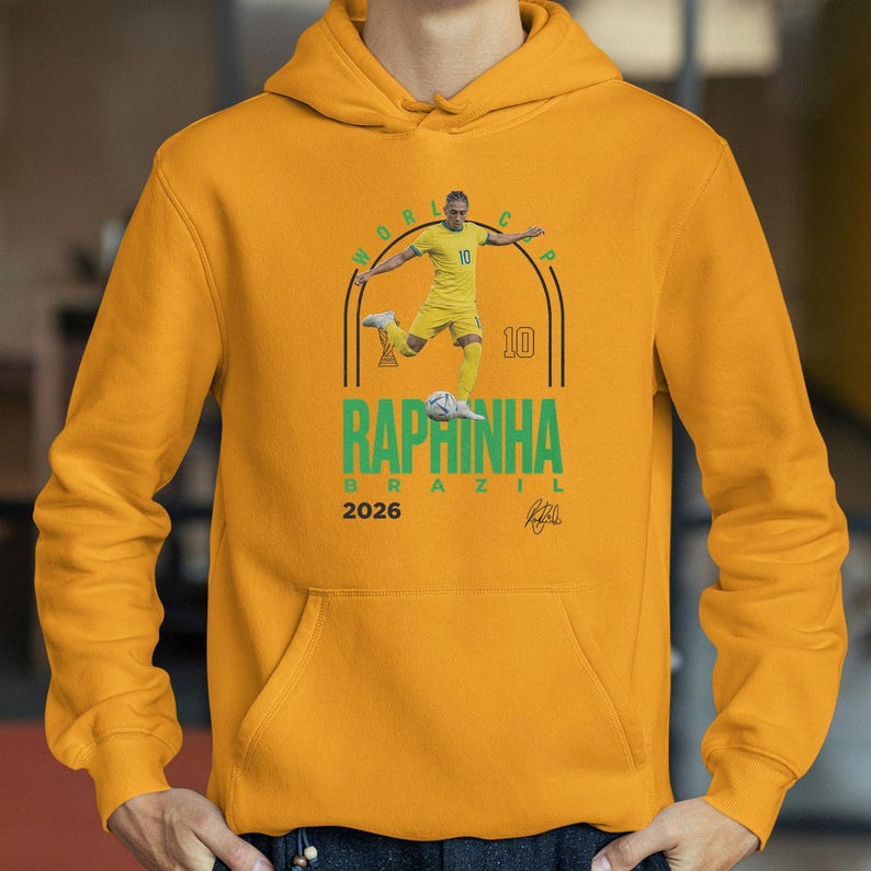 A yellow hoodie with a graphic design featuring a soccer player in yellow and the text "RAPRINHA BRAZIL" printed on it.