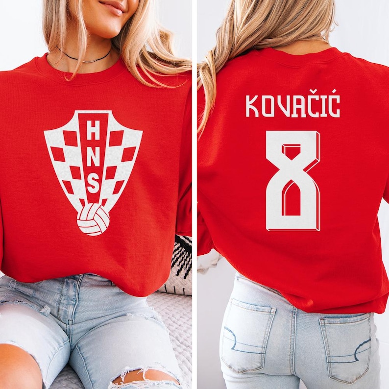 A woman wearing a red shirt with a white crest and the number 8 on the back, along with the text "KOVÁCÍK" printed on the back.