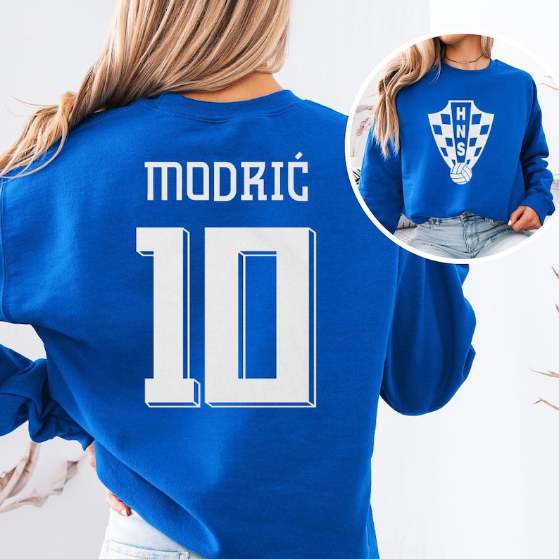 A woman wearing a blue sweatshirt with the number 10 and the name "Modric" printed on it.