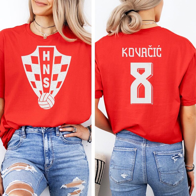 A woman wearing a red t-shirt with the Croatia national team logo and the number 8 on the back.