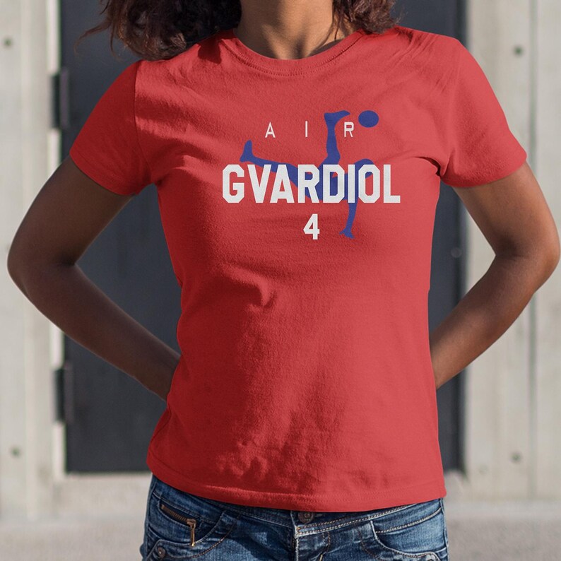 A woman wearing a red t-shirt with the text "AIR GVARDIOL 4" printed on it.